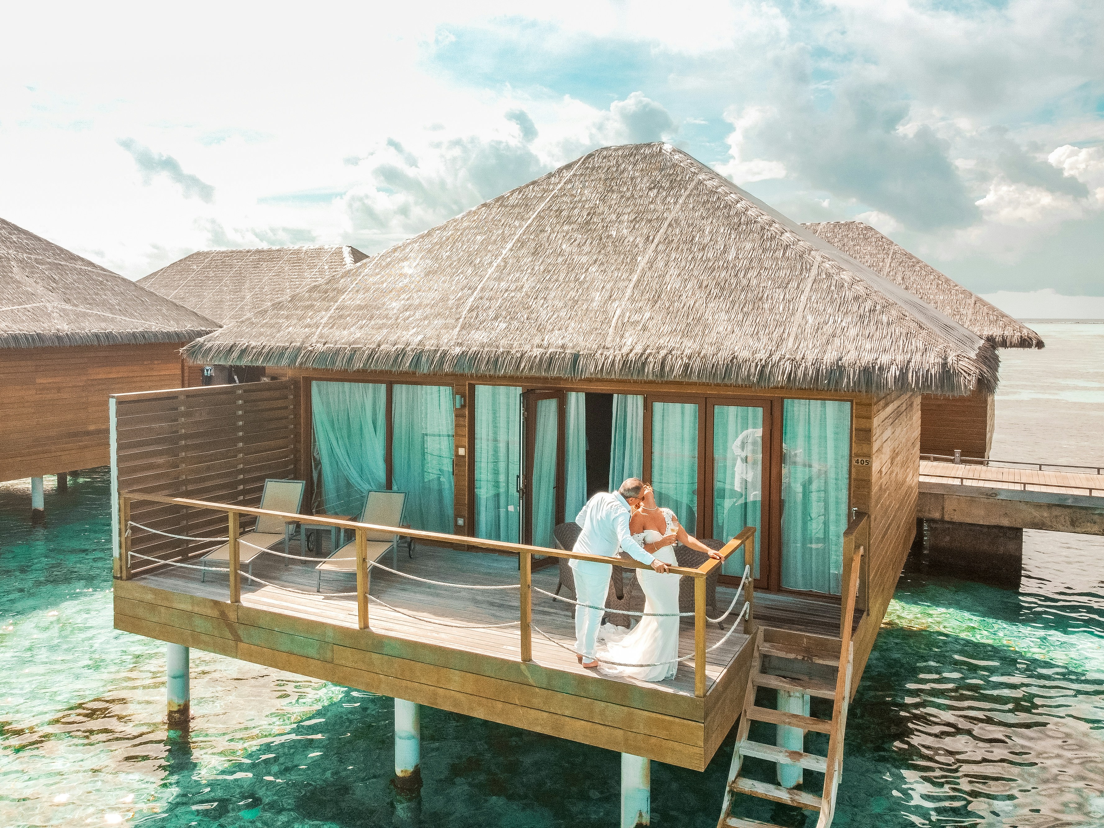 a man and a woman standing on a dock in front of a house