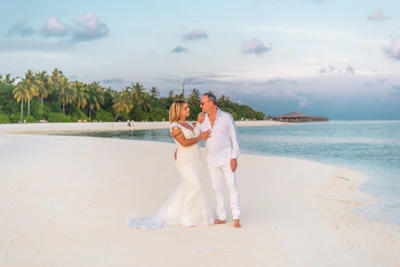 A happy couple exchanging vows on a tropical beach with turquoise waters.
