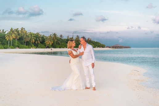 Couple relaxing on a pristine beach with turquoise water and clear blue sky