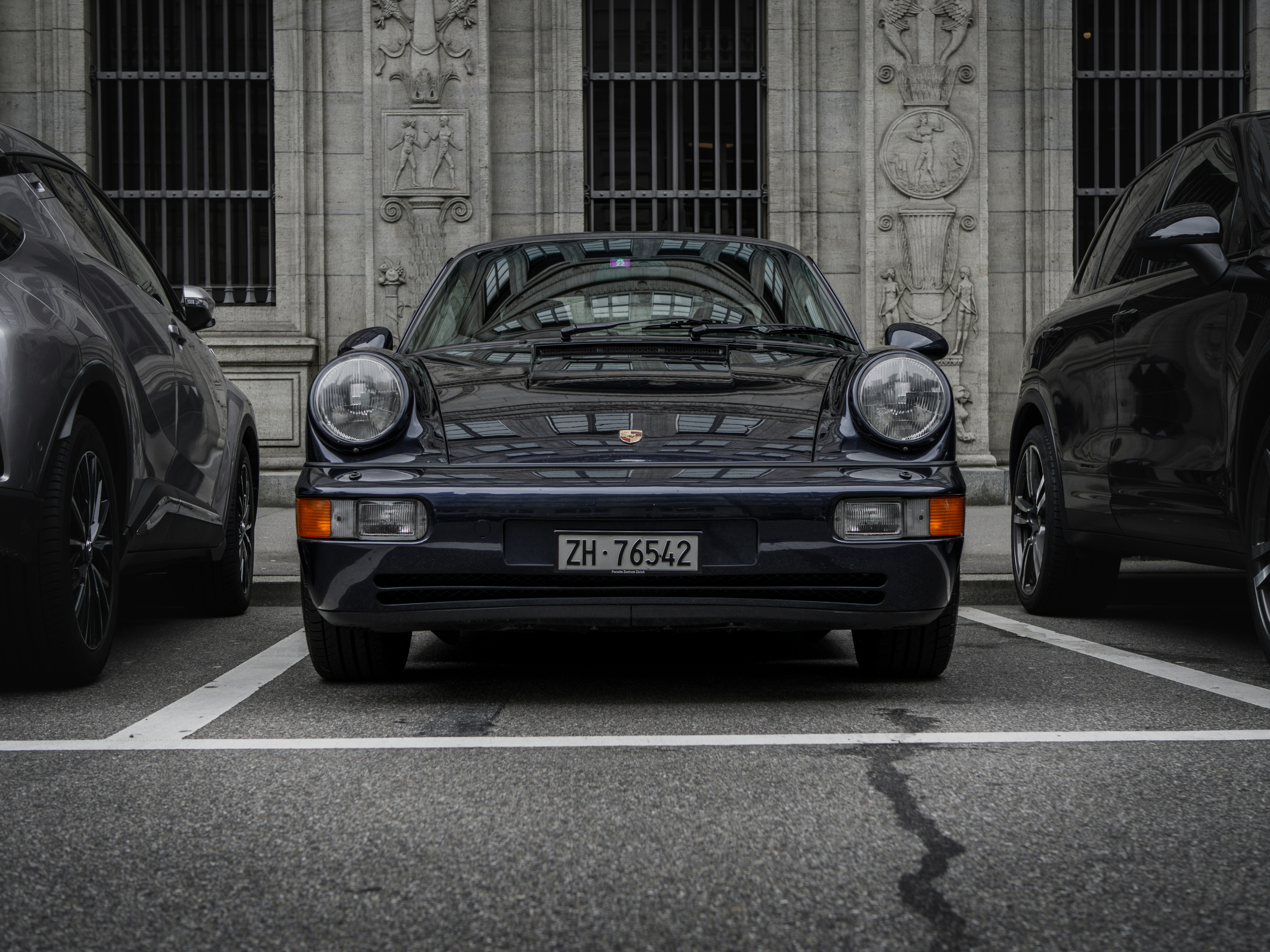 a black porsche parked in front of a building
