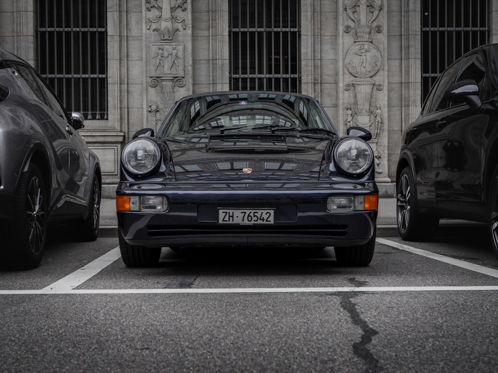 a black porsche parked in front of a building