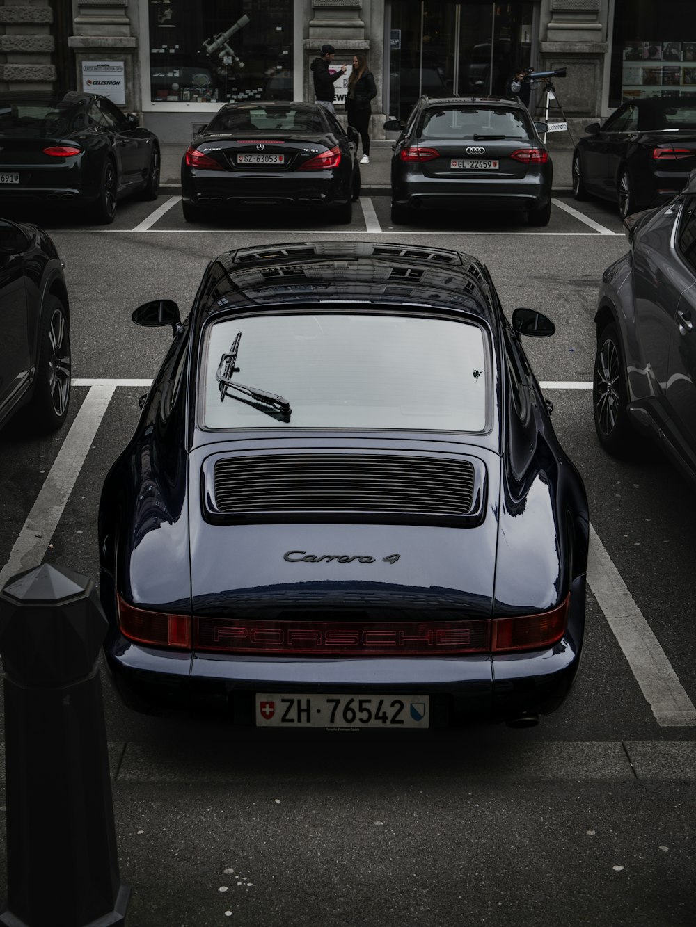 a black and white porsche parked in a parking lot