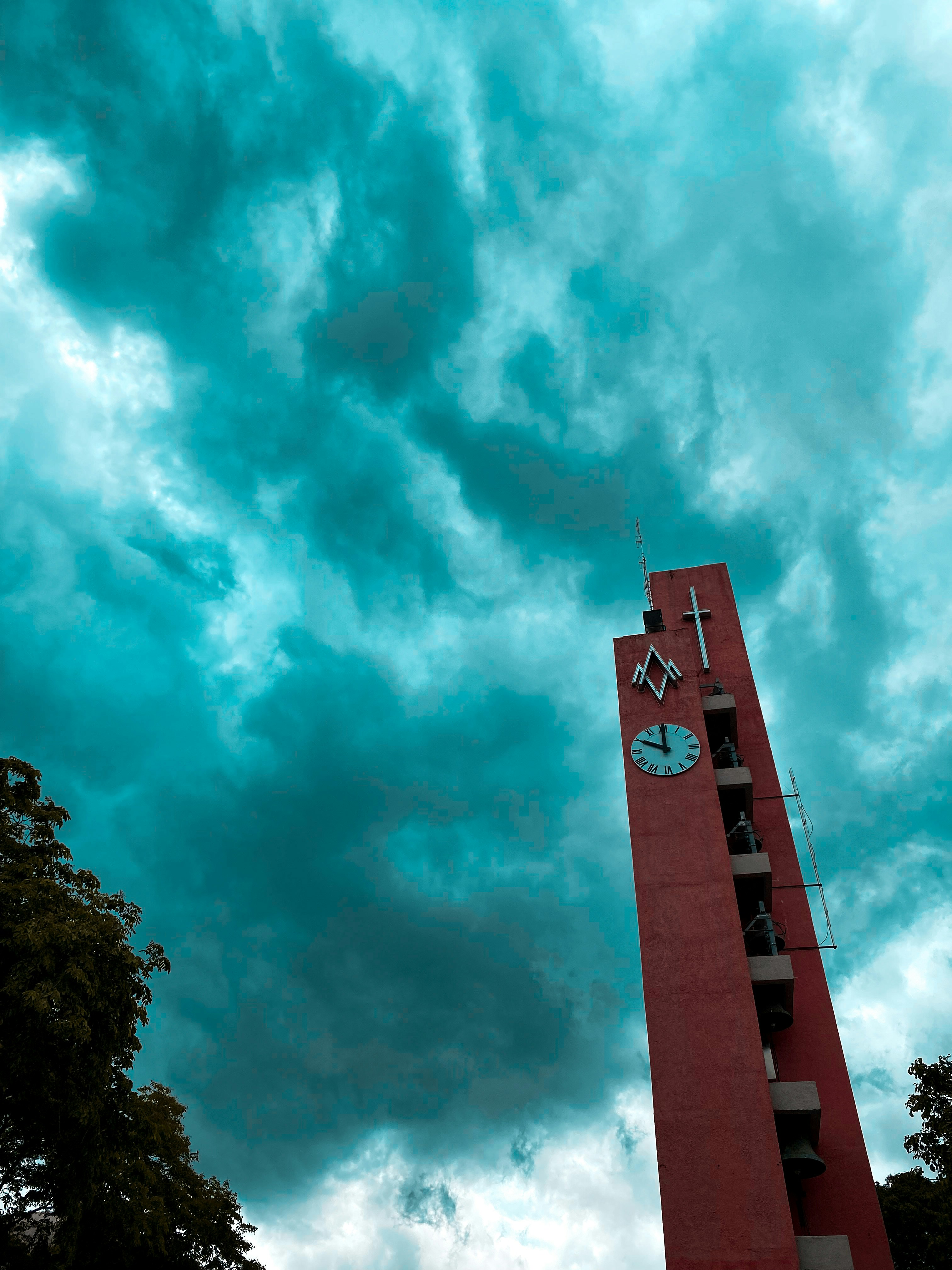 uma alta torre vermelha com um relógio ao lado dela