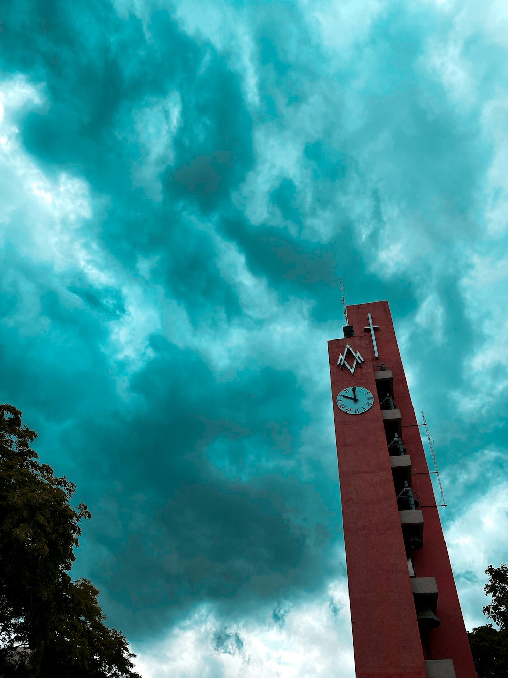 a tall red tower with a clock on the side of it