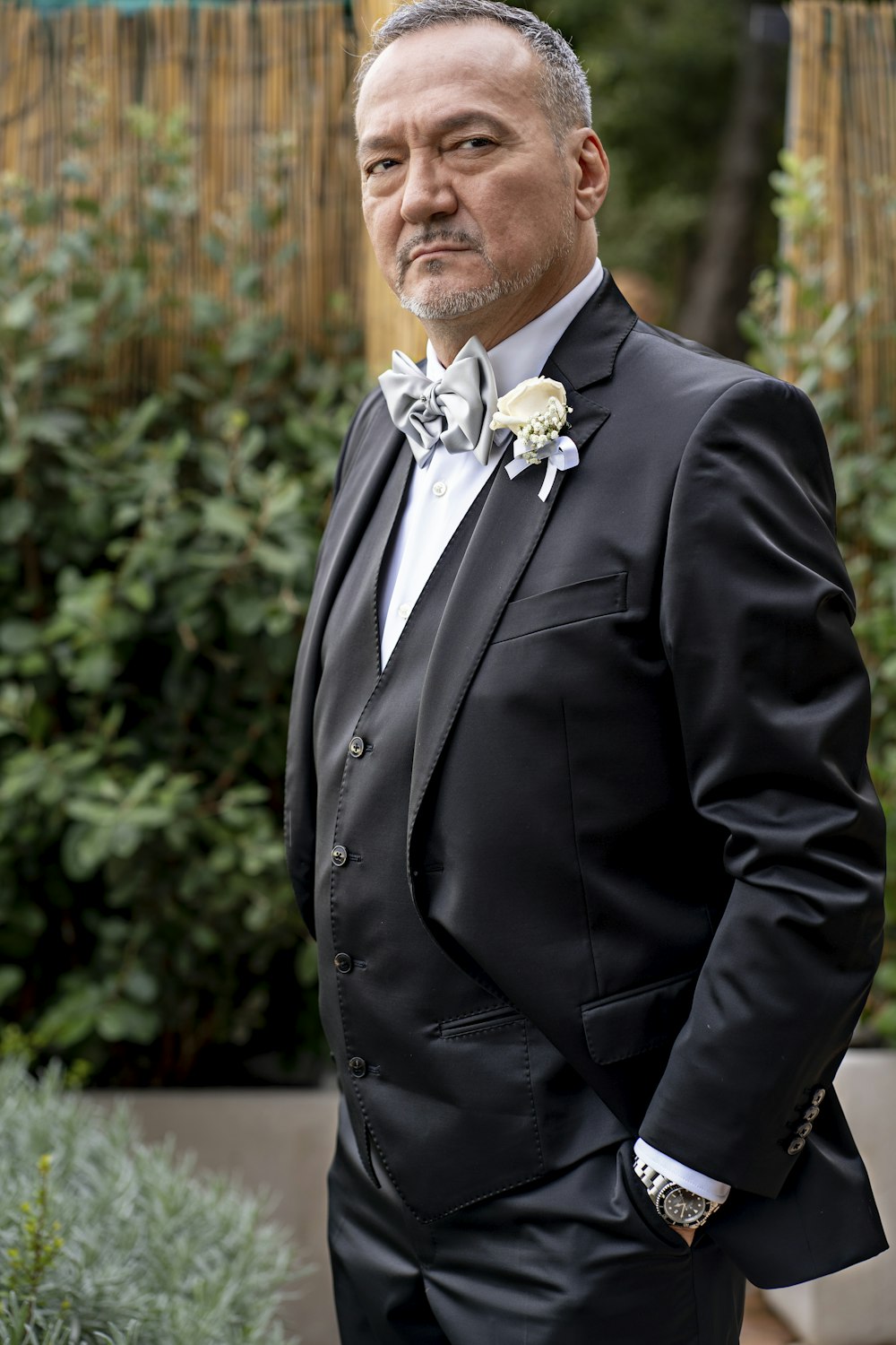 a man in a tuxedo is posing for a picture