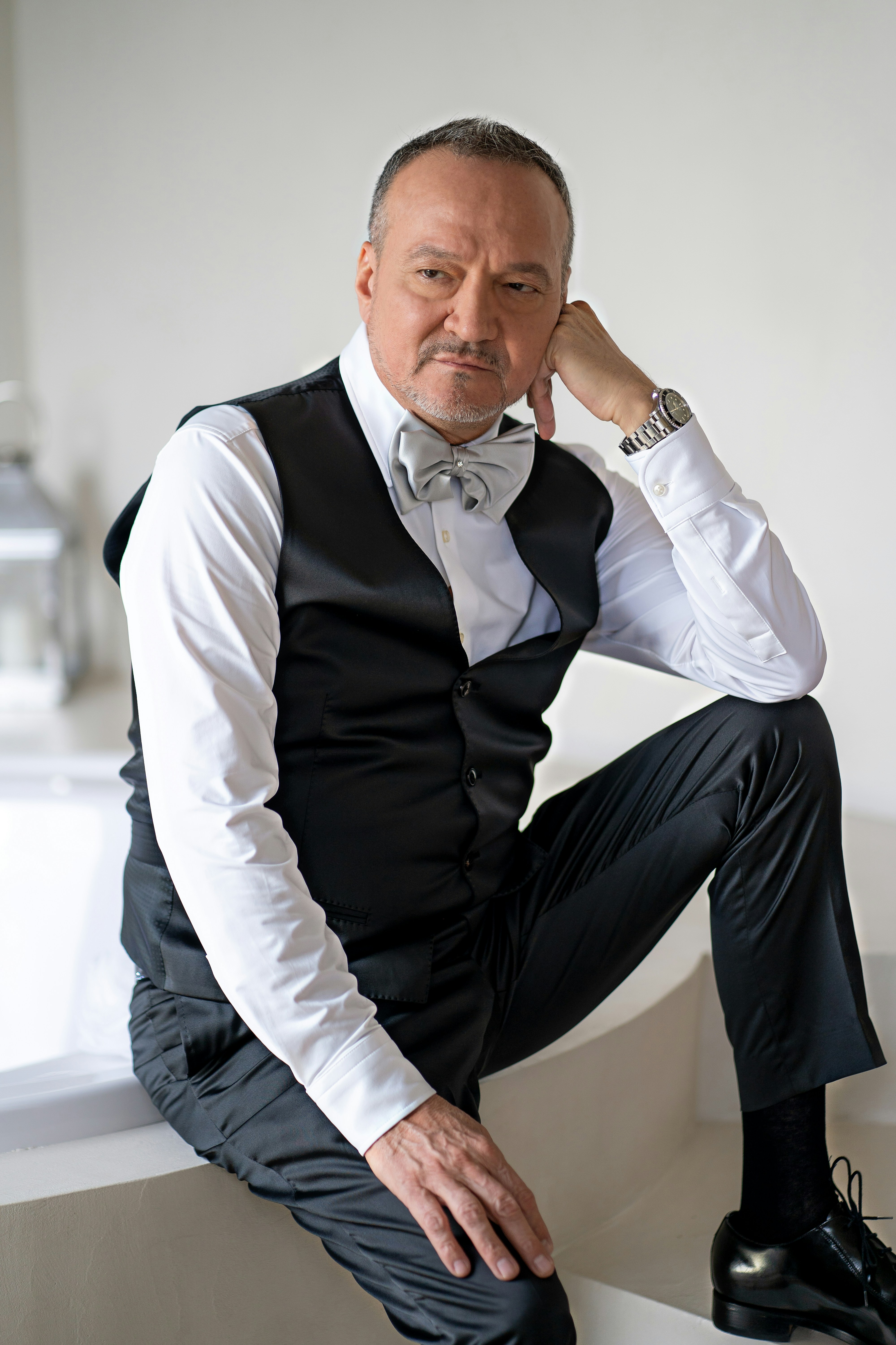 a man in a tuxedo poses for a picture