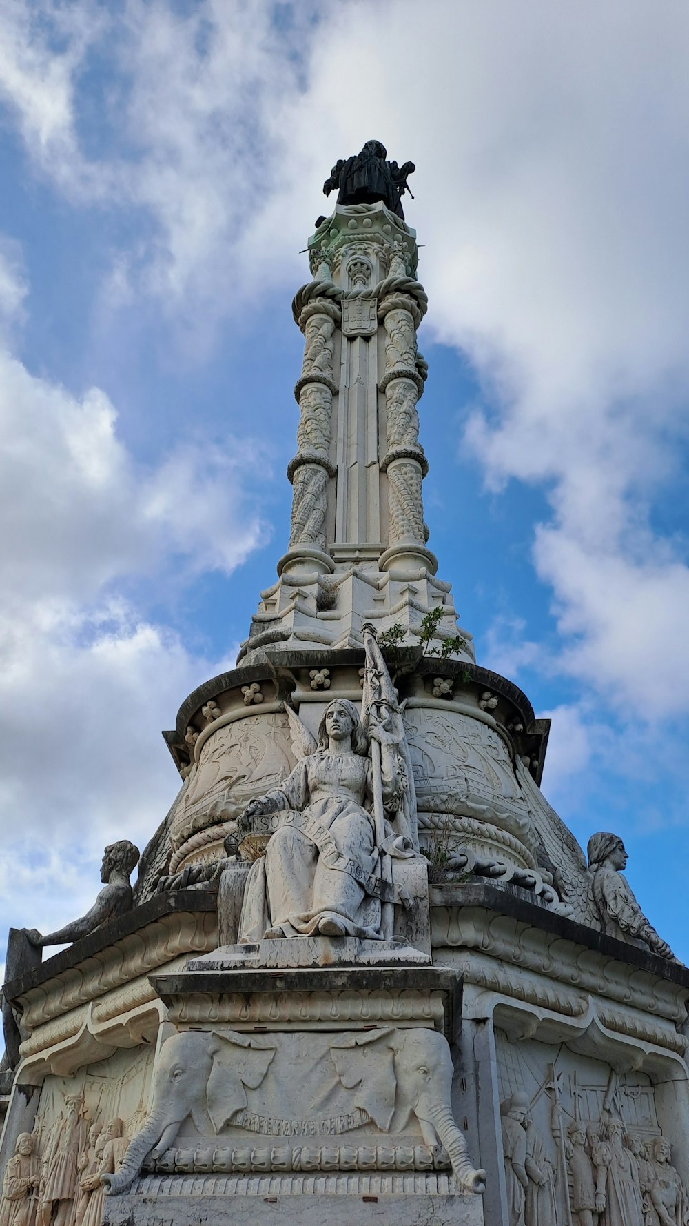 une statue au sommet d’un bâtiment avec un fond de ciel