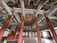 An intricately decorated interior space with colorful patterns on wooden columns and beams. The architecture features rich detailing on the ceiling and a harmonious blend of colors. The room has a spacious, symmetrical layout, with traditional Asian design elements throughout.