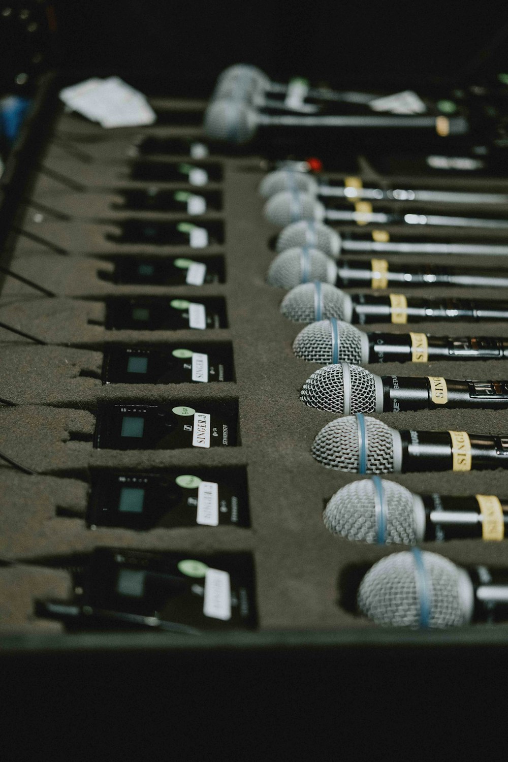a bunch of microphones lined up on a table