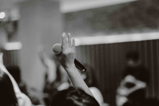 Hands holding a microphone during a community radio broadcast.