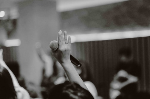 Hands holding a microphone during a community radio broadcast.