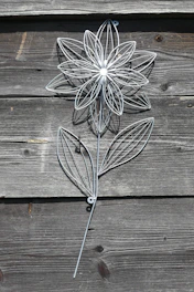 Decorative metal floral wall art with intricate petal details in warm tones.