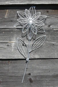 Intricate metal wall hanging with floral patterns in warm bronze tones.