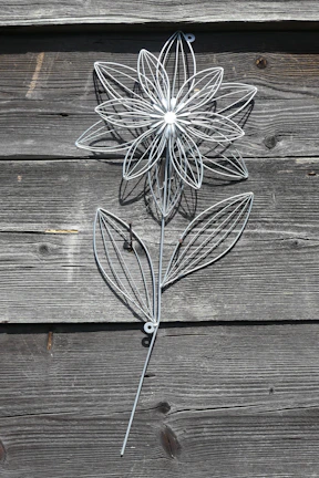 Intricate metal floral wall art featuring blooming roses with delicate leaves.