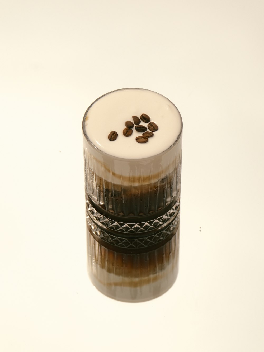 a shot glass filled with coffee beans on top of a table
