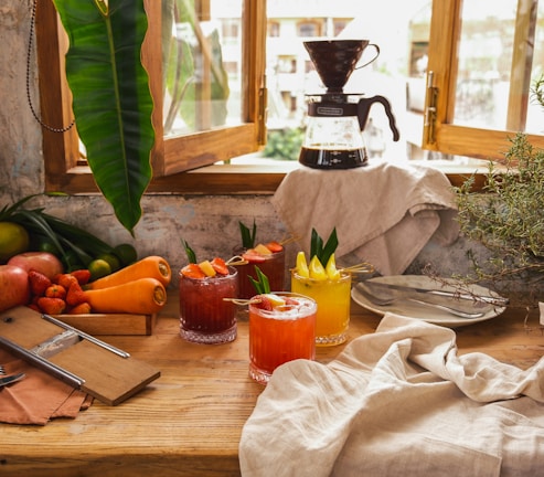 Fresh fruits and beverages artistically arranged on a rustic market table.