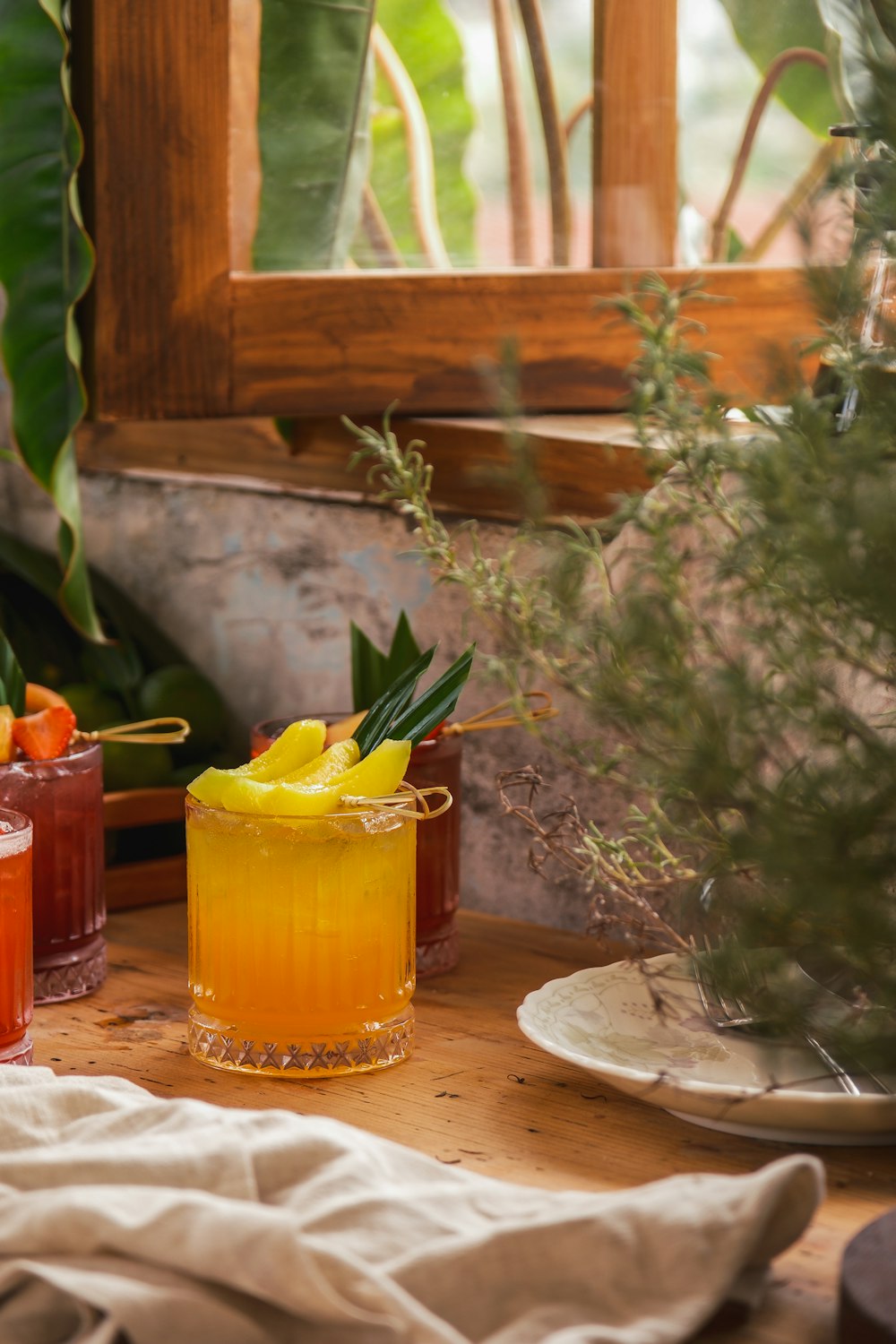 a wooden table topped with glasses filled with drinks