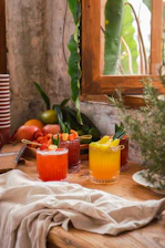 Fresh mocktail with colorful fruit garnishes on a clean white table in a modern cafe setting.