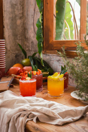 Fresh mocktail with colorful fruit garnishes on a clean white table in a modern cafe setting.