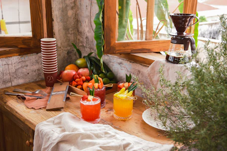 A cozy kitchen scene with a woman preparing a healthy smoothie surrounded by fresh fruits.