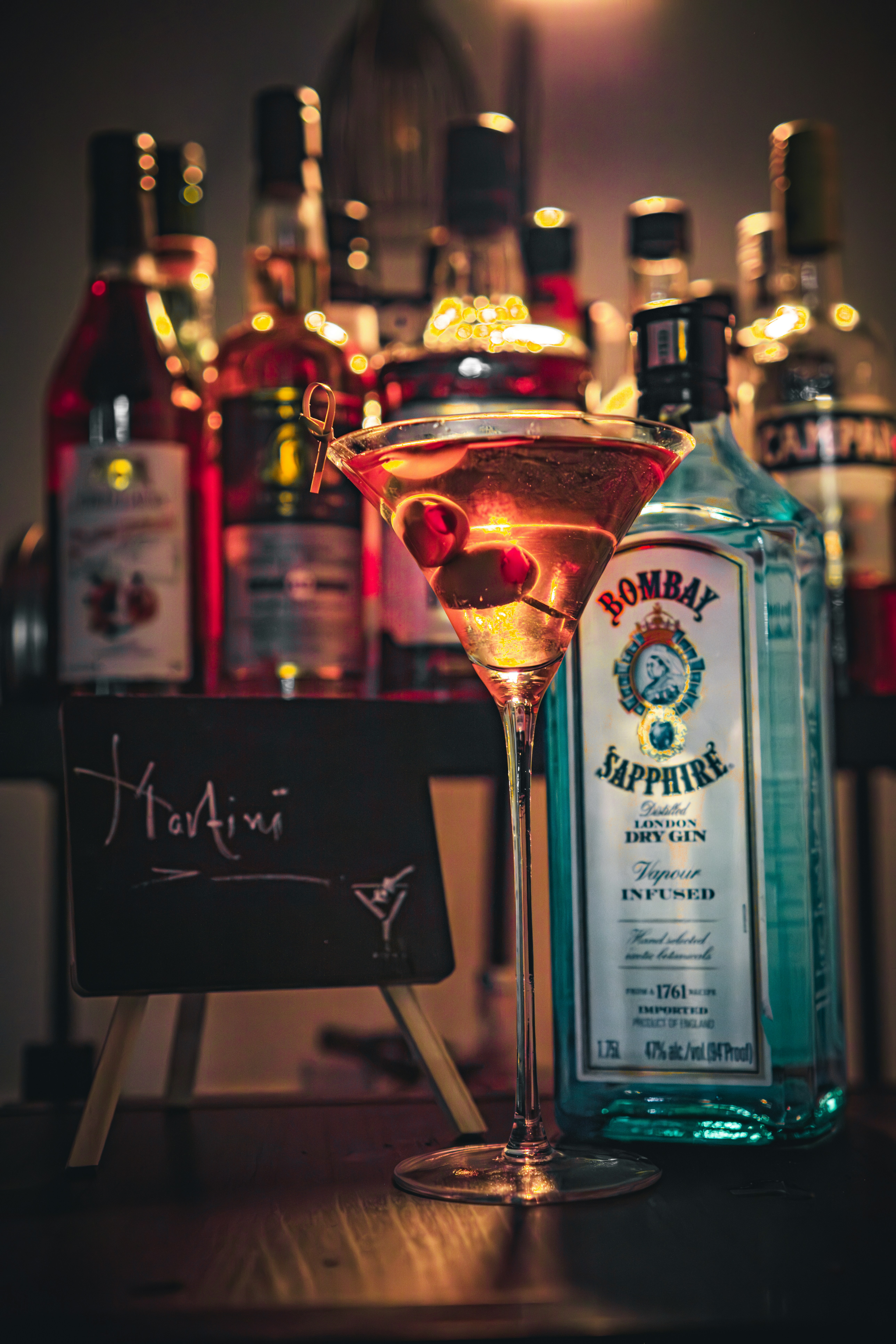 a glass filled with a liquid next to a bottle of alcohol