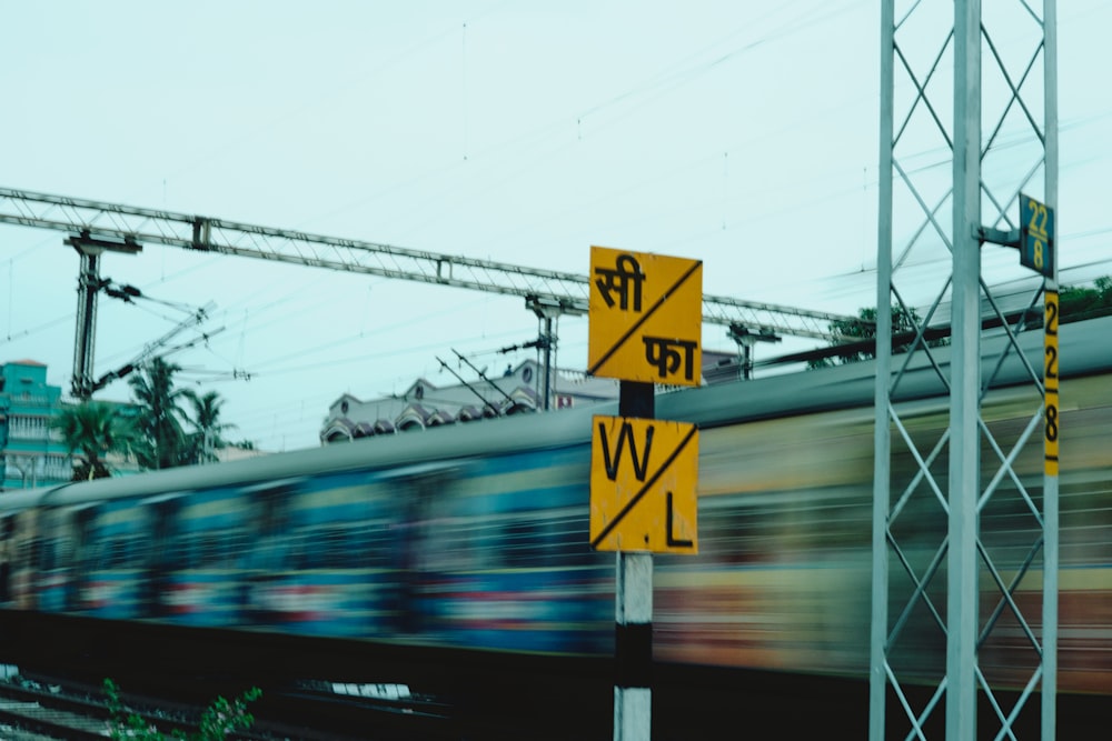 a train passing by a railroad crossing sign