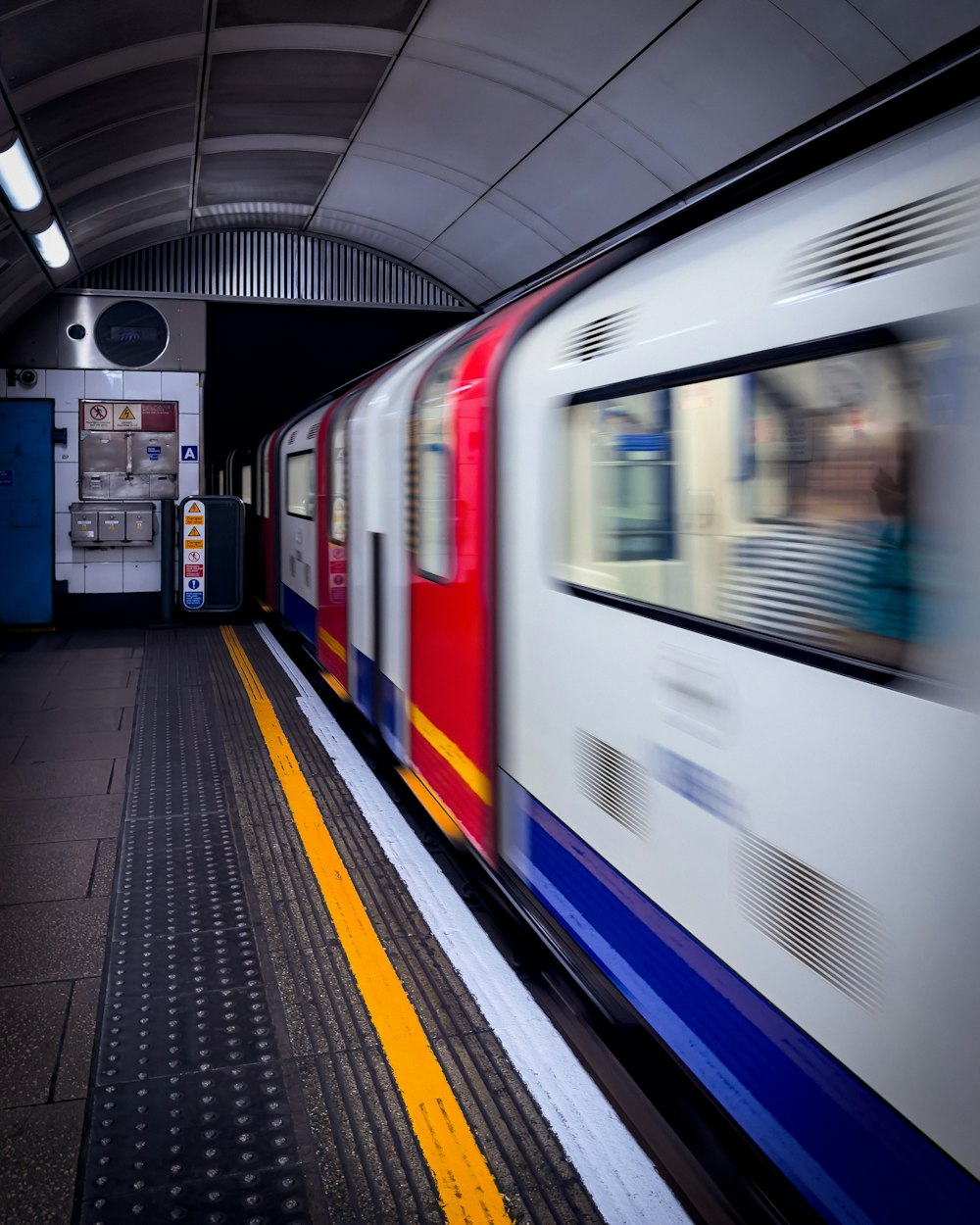 a train traveling through a train station next to a loading platform