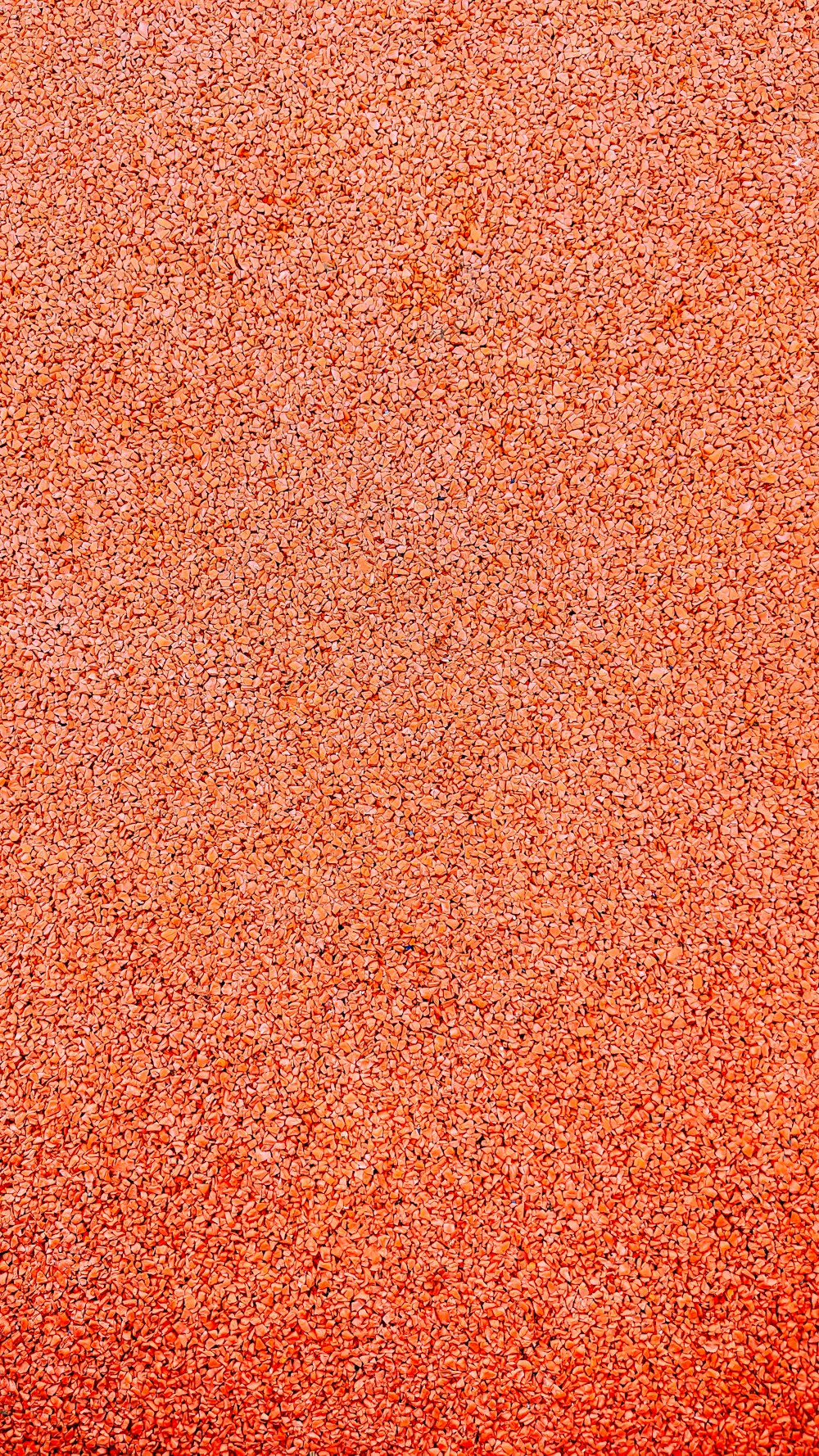 a close up of a red surface with small speckles