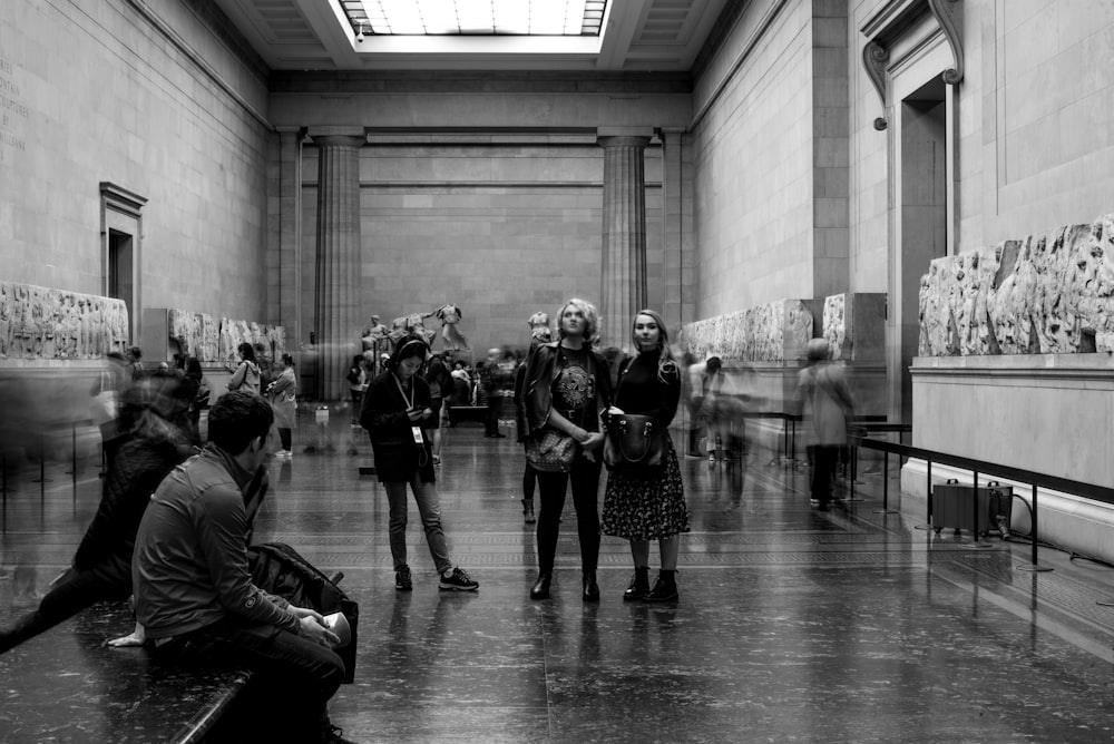 a black and white photo of people in a museum