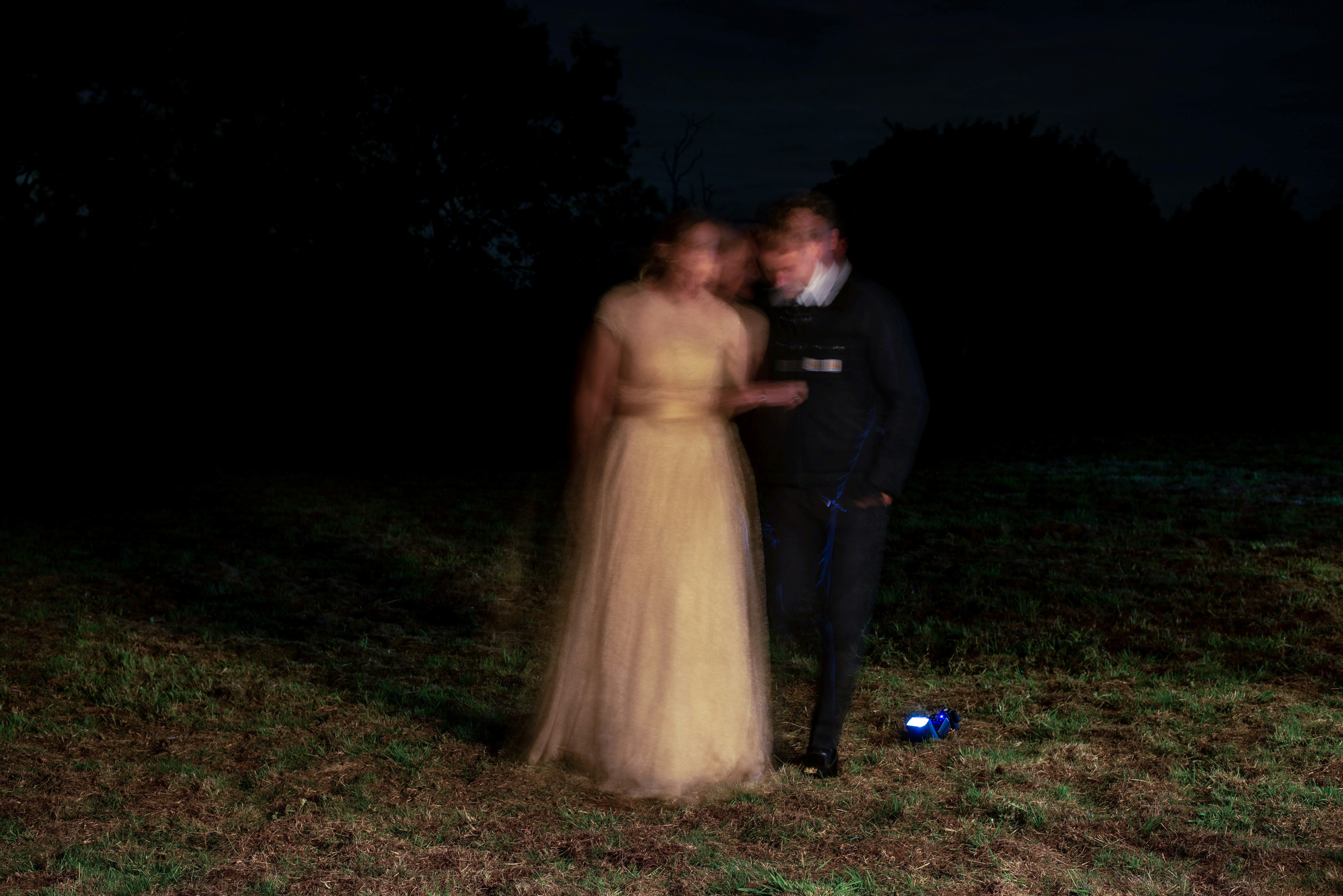ein mann und eine frau, die nachts auf einem feld stehen