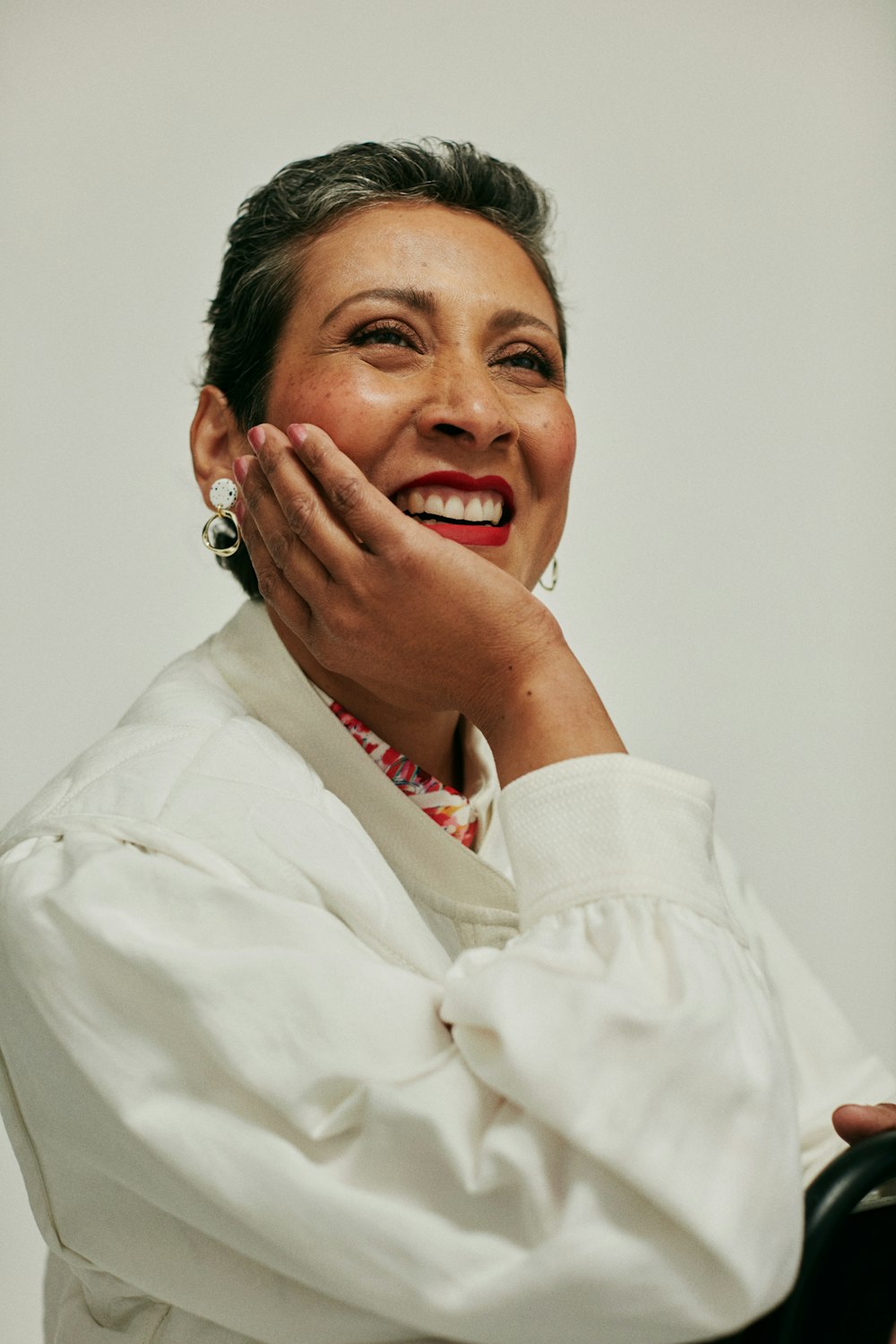 a woman in a white shirt is smiling