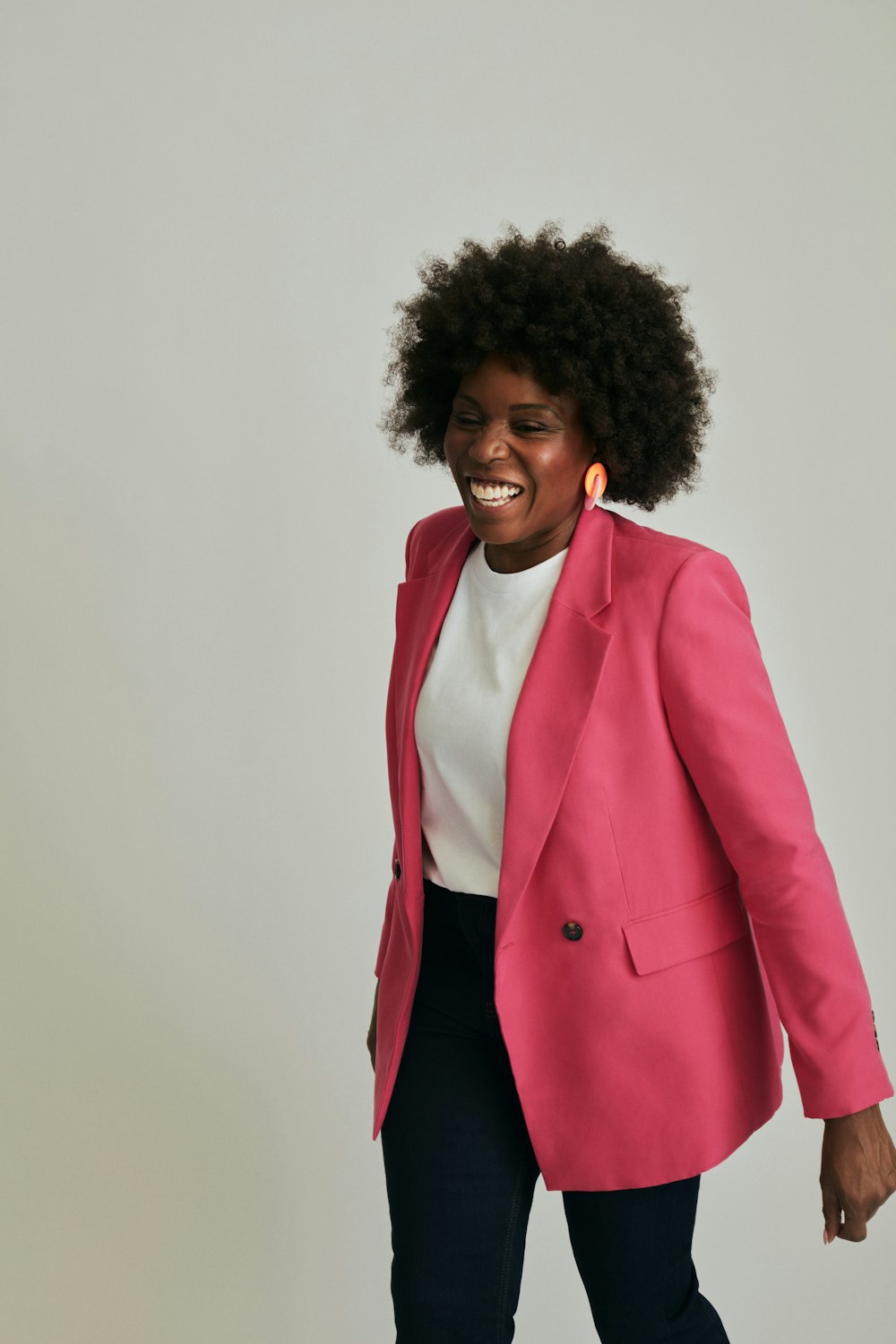 a woman in a pink blazer and black pants