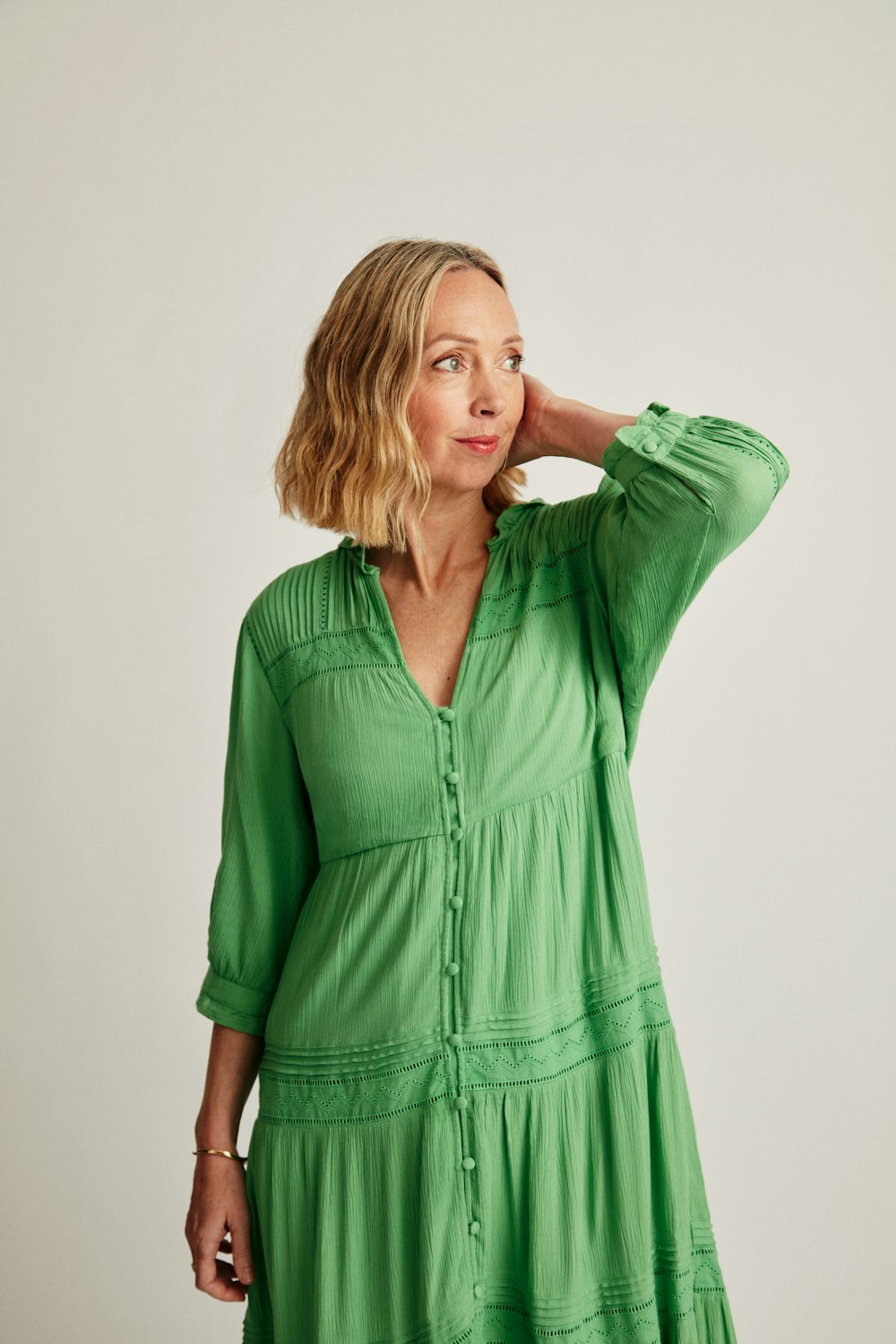 a woman in a green dress posing for a picture