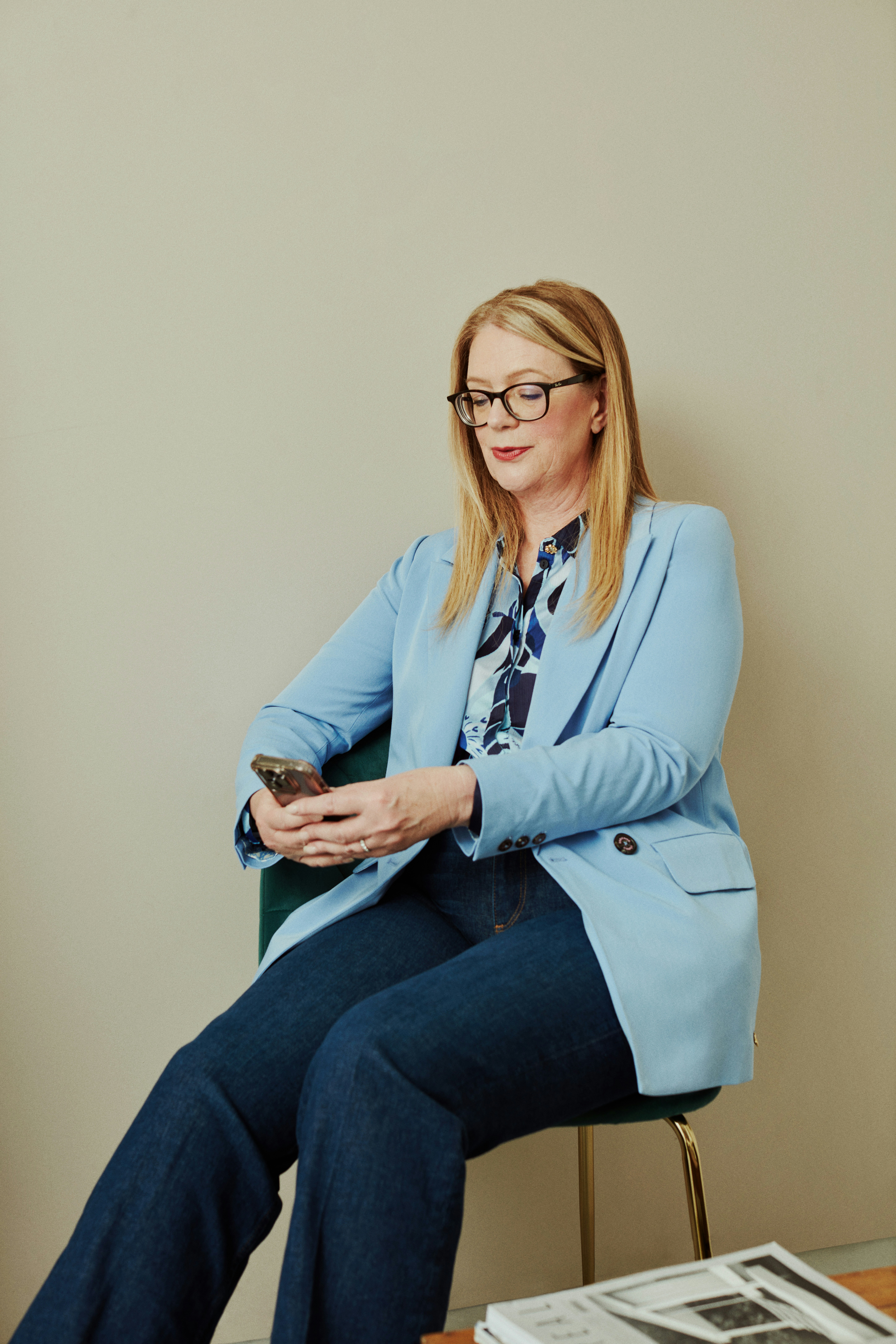 a woman sitting in a chair looking at her cell phone