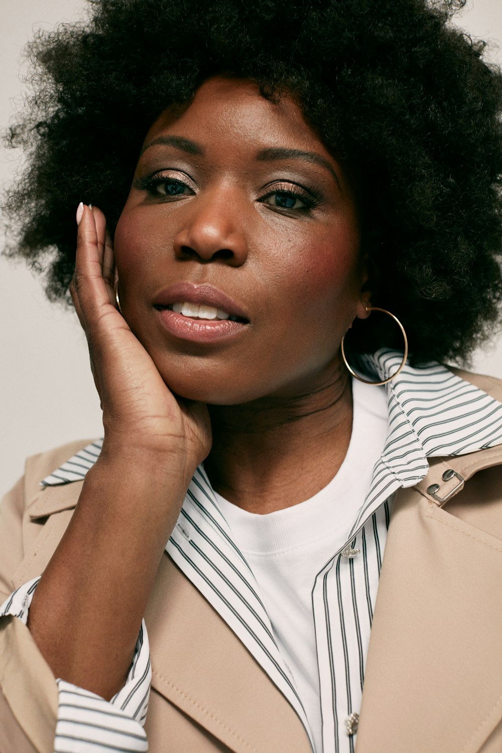 a woman with an afro is posing for a picture