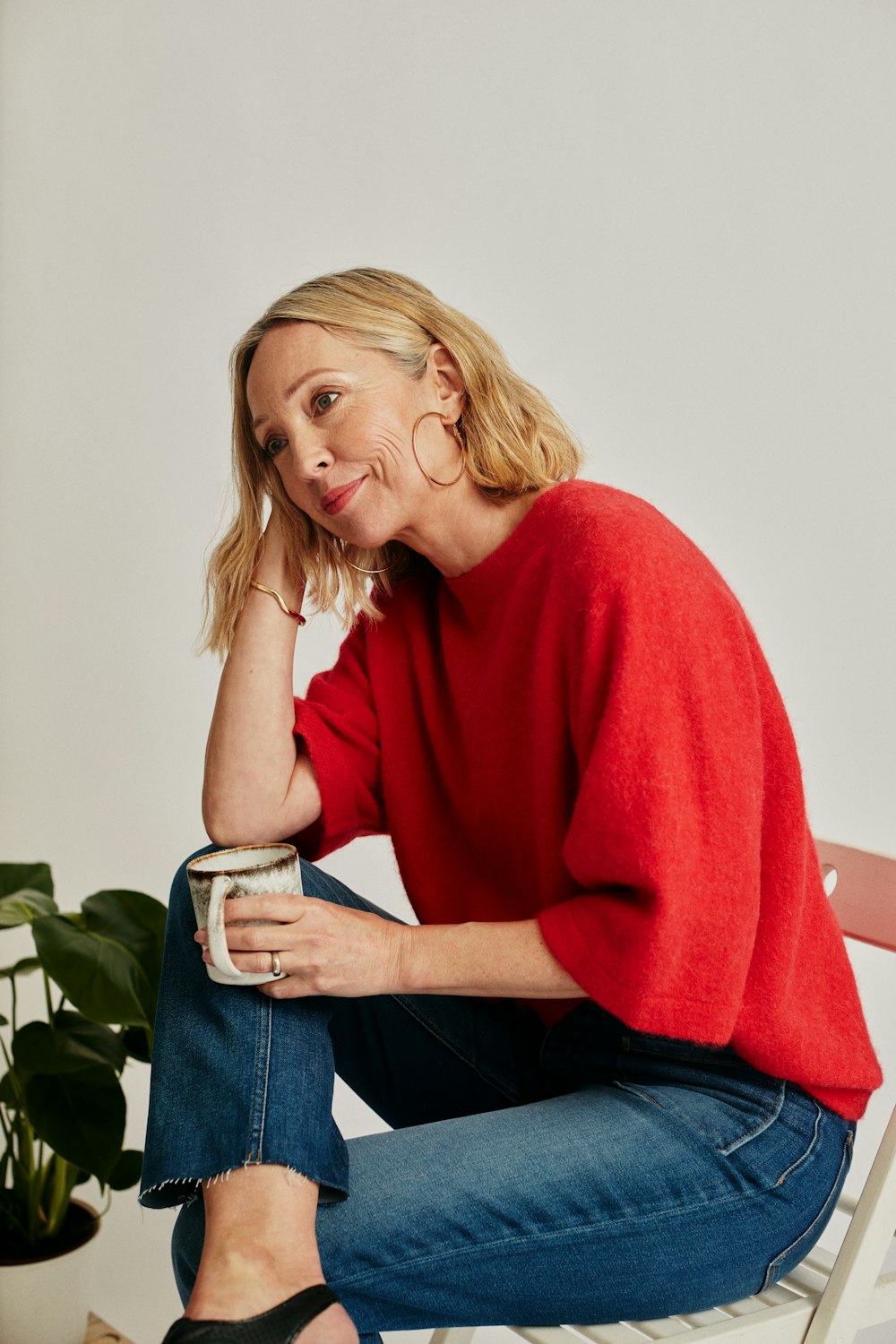 a woman sitting on a chair holding a can