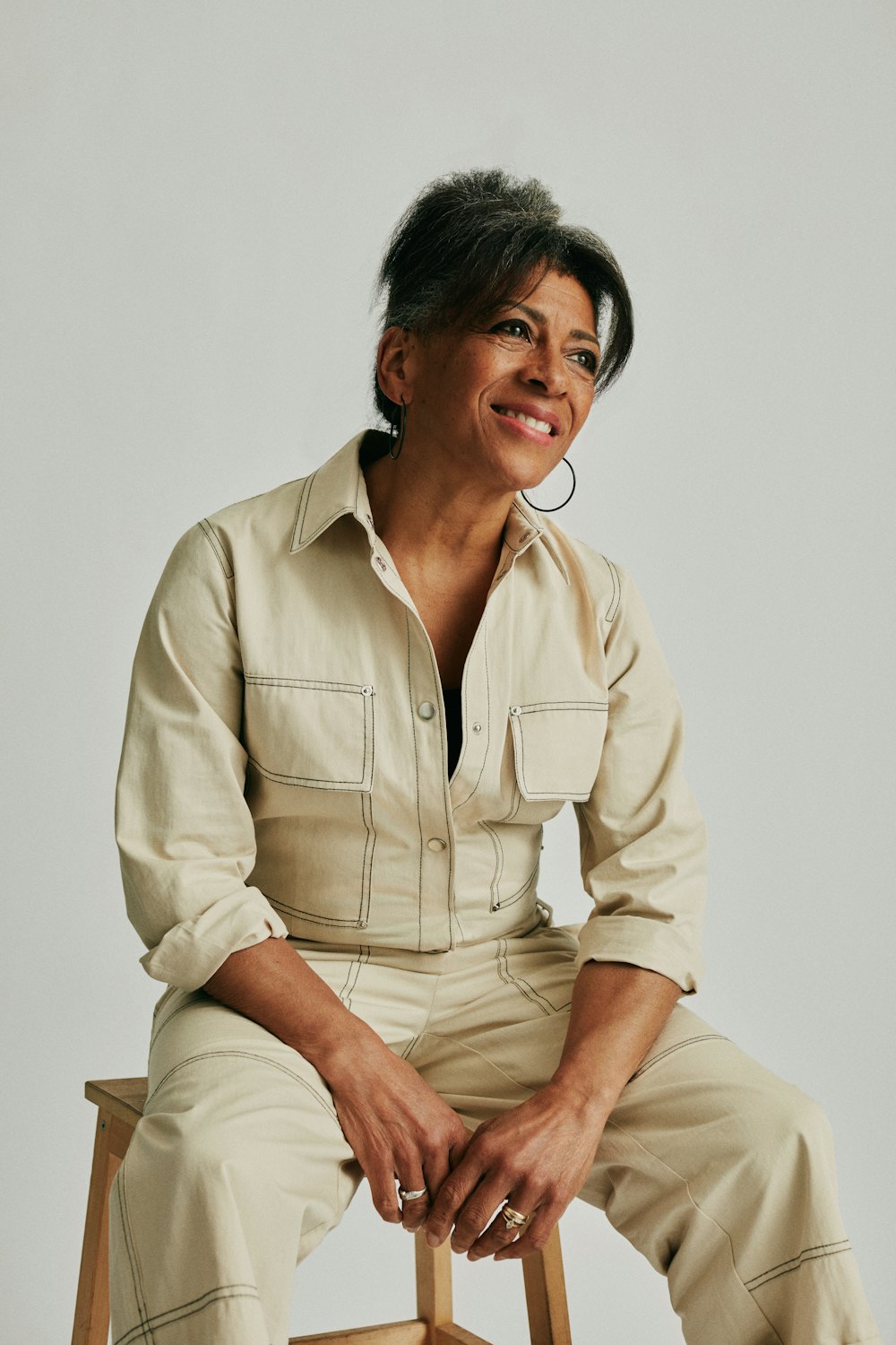 a woman sitting on top of a wooden chair