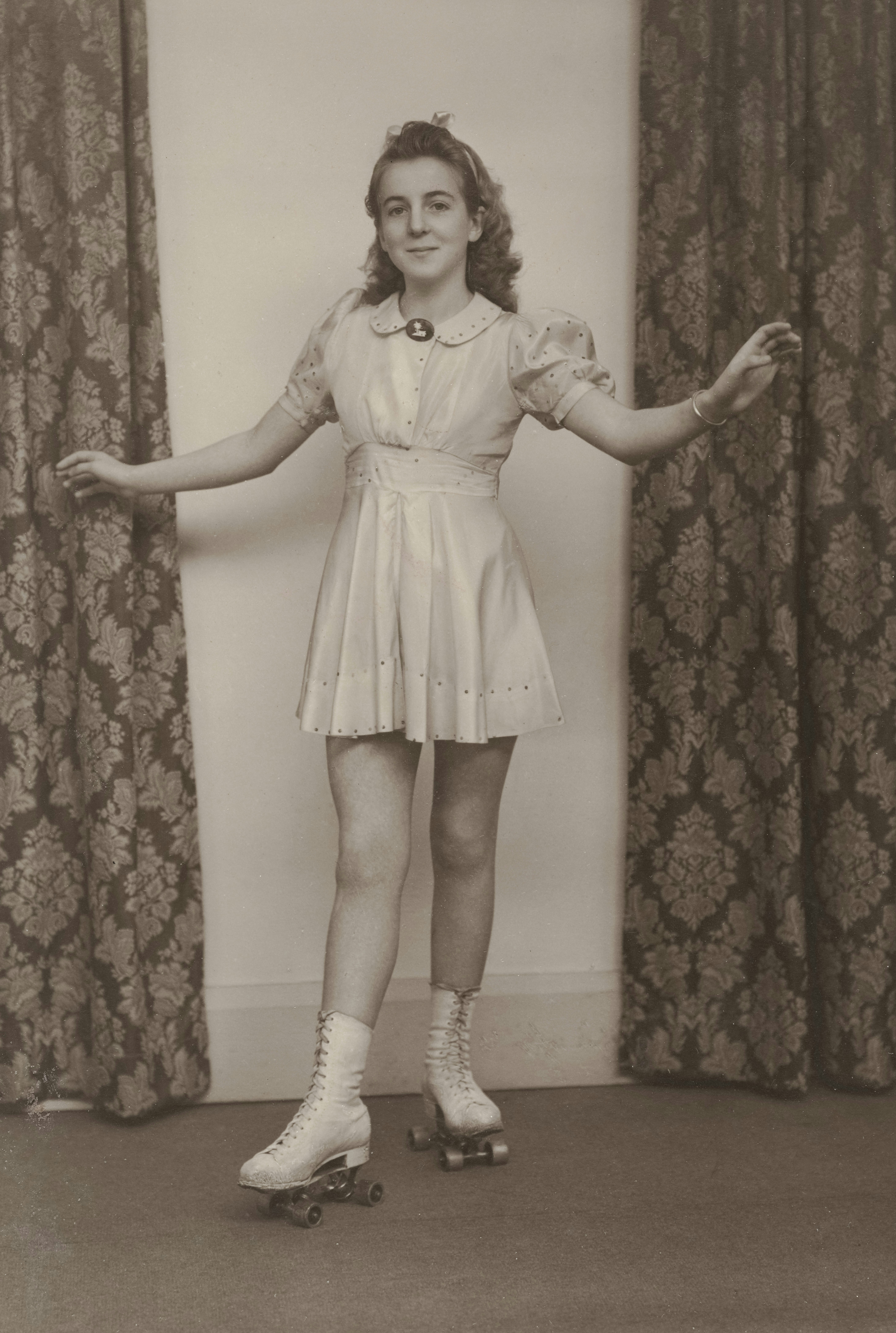 An old photo of a woman standing on roller skates photo Free