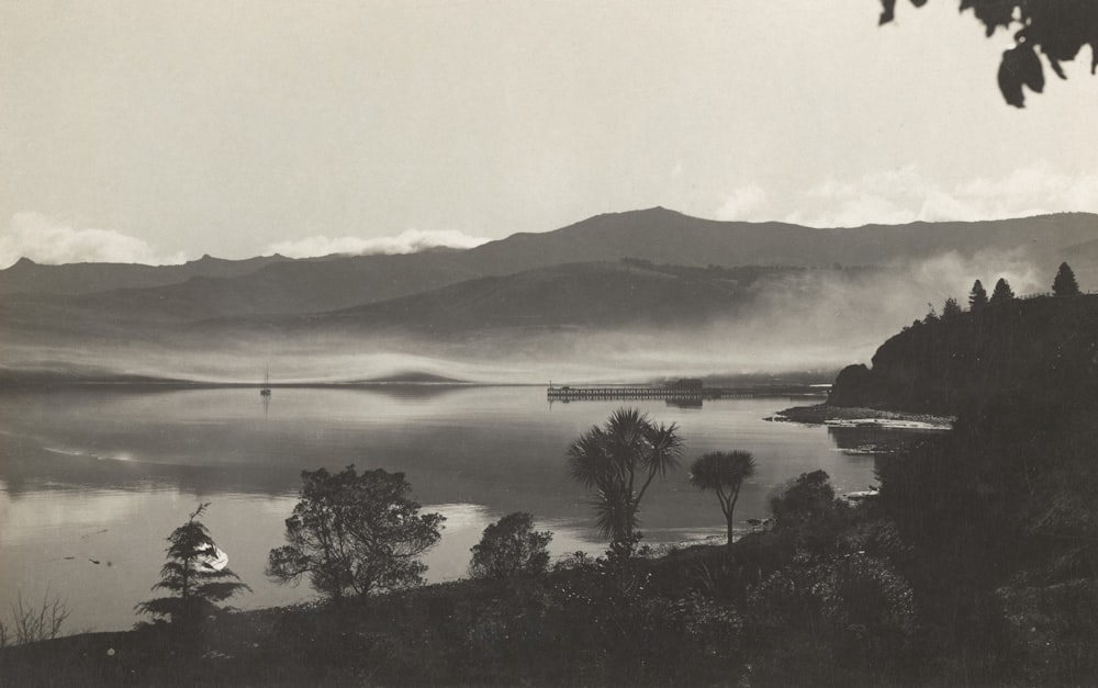 uma foto em preto e branco de um lago e montanhas