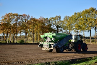 a tractor is driving down a dirt road