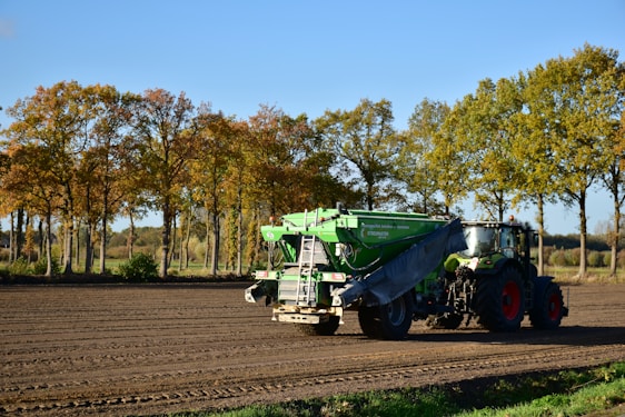 a tractor is driving down a dirt road