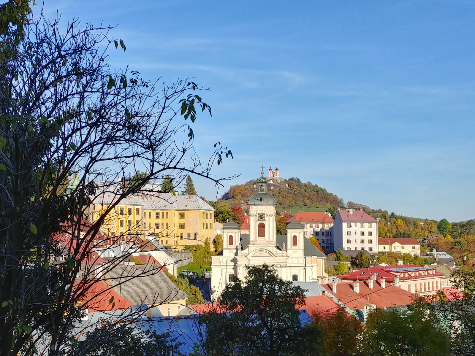 The town’s churches and roofs on the hillside, with the calvary above — Banská Štiavnica, Slovakia