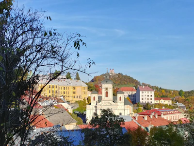The town’s churches and roofs on the hillside, with the calvary above — Banská Štiavnica, Slovakia