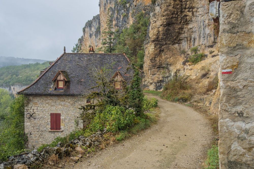 a stone building with a red door on a mountain side