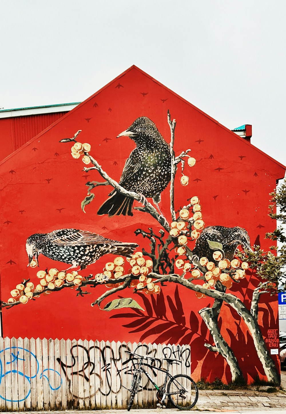 a red building with a bird painted on it