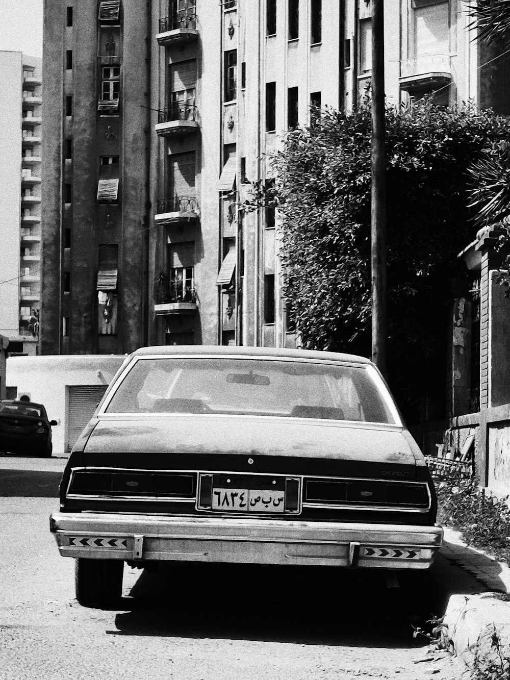 a black and white photo of a car parked on the side of the road