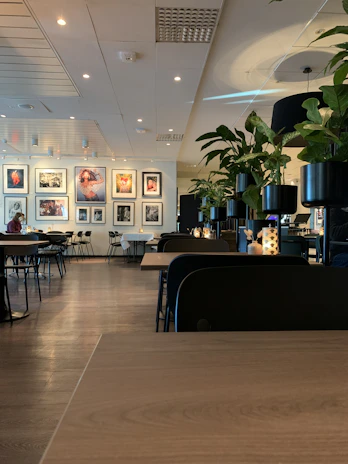 Wide shot of the café interior featuring sleek wooden tables, soft lighting, and dark accent walls.