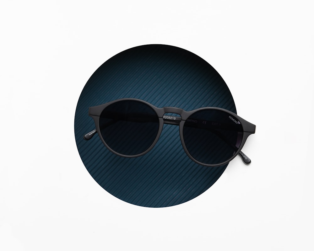 a pair of sunglasses sitting on top of a blue circle