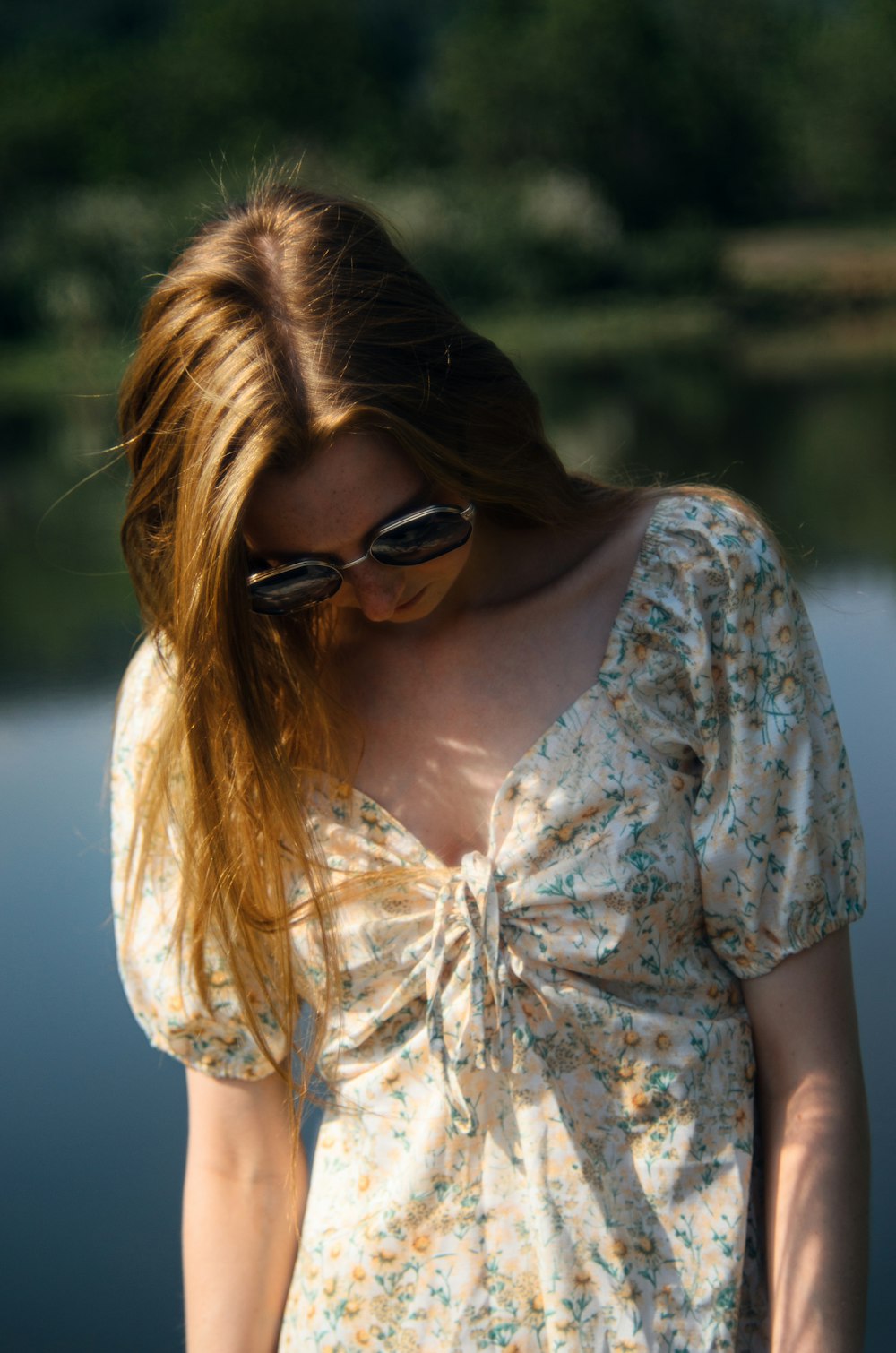 a woman in a dress is standing by the water