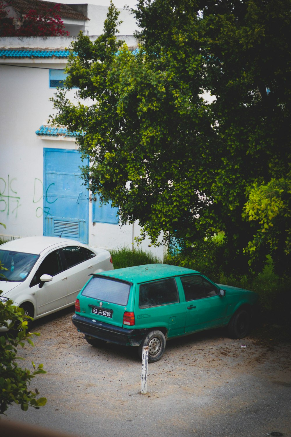two cars parked in front of a white building